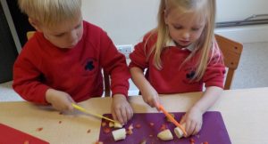 Transition children chopping up fruit to make a smoothie